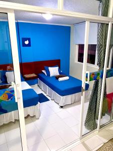 圣安德烈斯Apartment Angeluz的蓝色的客房配有两张床和镜子