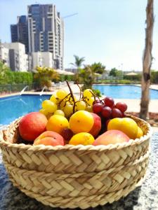 Sheikh ZayedLuxury Stay的一张桌子上一篮水果,靠近一个游泳池