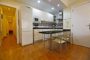 特尔德瓦斯科达伽马公寓的厨房配有桌椅和冰箱。