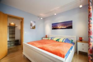 萨斯尼茨Meerforelle 207 - Villa Seeblick的一间卧室配有一张带橙色毯子的床