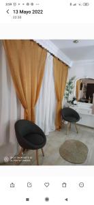 福恩吉罗拉Ático Sofía, gran terraza y barbacoa的客厅配有2把黑色椅子和窗帘