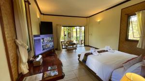 象岛花园度假酒店的一间卧室配有一张床和一台平面电视