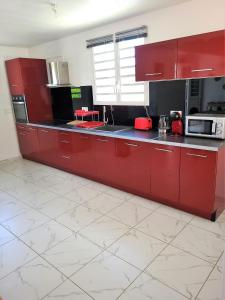 莱特鲁瓦西莱Maison Indép, Spa, Mer, Jardin, Bien-être的一间厨房,配有红色橱柜和台面