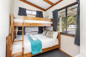基督城南北度假公园的一间位于小房子内的卧室,配有双层床