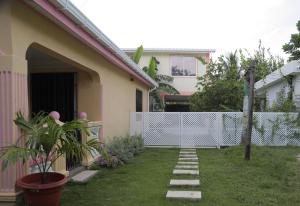 圣安德烈斯Posada Mango House的一座带白色围栏的房屋的后院
