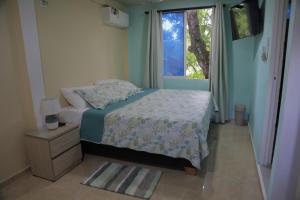圣安德烈斯Posada Mango House的一间小卧室,配有床和窗户