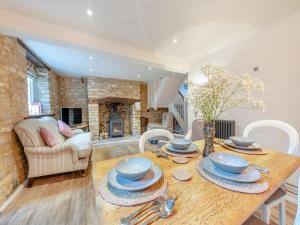 IdburyPatience Cottage的厨房以及带木桌和椅子的客厅。