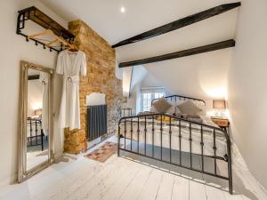 IdburyPatience Cottage的一间卧室设有一张床和砖墙
