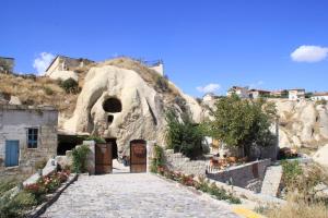 奥塔希萨尔CAPPADOCİA ST.NİNO'S GARDEN的通往带门的洞穴的石道