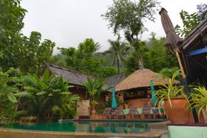 Nongkhiaw曼陀罗欧度假酒店的一个带游泳池、椅子和树木的度假酒店