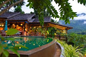 Nongkhiaw曼陀罗欧度假酒店的一座带游泳池的度假村,位于一座房子前