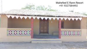 BherandiālaMahefeel e Rann Resort的茅草屋顶和门的小房子