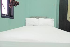 打拉根SPOT ON 91791 Homestay Surya Syariah的一张带白色床单和枕头的床