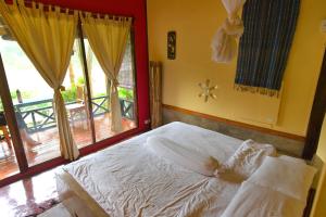 Nongkhiaw曼陀罗欧度假酒店的一间卧室设有一张床和一个大窗户
