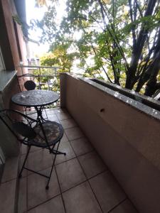斯拉沃尼亚布罗德Apartman Lipa的阳台配有桌椅和窗户。