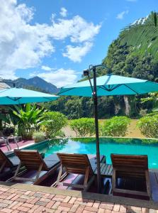 Nongkhiaw曼陀罗欧度假酒店的一个带两把椅子和遮阳伞的游泳池