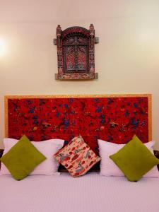 斋沙默尔香缇之家酒店的一张带红色床头板和枕头的床