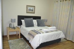 逊邱伦Green Grove Villa的一间卧室配有两张床和一张带两盏灯的桌子。