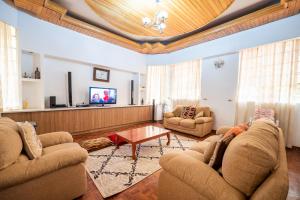 内罗毕spacious & stylish 4bdr kileleshwa的客厅配有两张沙发和一台电视机