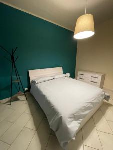都灵Grazioli House的卧室配有白色的床和绿色的墙壁