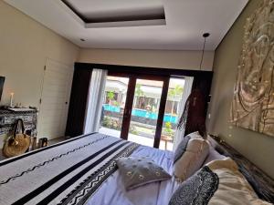 努沙杜瓦Kubu Garden Suites & Villas Nusa Dua的一间卧室设有一张床和一个大窗户
