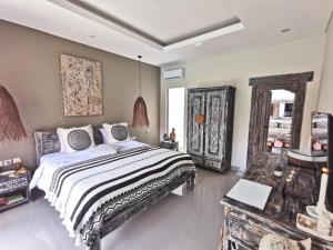 努沙杜瓦Kubu Garden Suites & Villas Nusa Dua的一间卧室配有一张大床和镜子