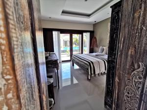 努沙杜瓦Kubu Garden Suites & Villas Nusa Dua的一间卧室配有一张床、梳妆台和镜子