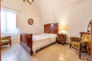 安德里亚Locazione turistica Lorusso 1的一间卧室配有一张床、镜子和椅子