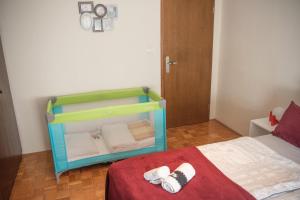 罗加斯卡斯拉提纳Apartment Karlie - cycling - other unique experiences的一间卧室配有一张带彩色婴儿床的床