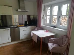贝希特斯加登BergZeit Apartment的厨房配有白色的桌子和两把椅子