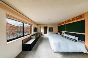 京都京都雅然居酒店的一间卧室设有一张大床和一个大窗户