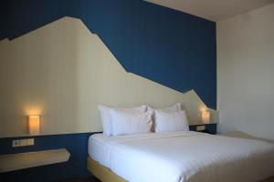 庞越庞越布鲁姆公园酒店 的卧室配有白色床和蓝色墙壁