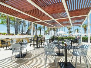 帕福斯莱昂纳多广场塞浦路斯马里斯海滩酒店及Spa的餐厅的露台,配有桌椅