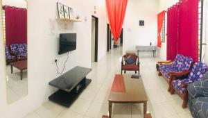 太平Homestay Lestary near Taiping Fast WIFI Netflix的客厅配有沙发、椅子和电视