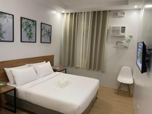 公主港Bambu Suites的酒店客房设有白色的床和电视。