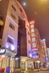 新德里Hotel Grand Godwin - Near New Delhi Railway Station - Paharganj的一群晚上有 ⁇ 虹灯标志的建筑