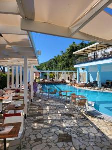 贝尼蔡斯Lido Corfu Sun Hotel 4 Stars All-inclusive的一个带桌椅的度假村游泳池