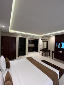 阿哈达Al Muhaidb Al Taif Hotel的一间大卧室,配有一张大床和一台平面电视