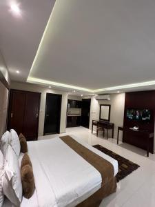 阿哈达Al Muhaidb Al Taif Hotel的一间带大床的卧室和一间客厅