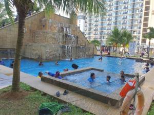 关丹Swiss Garden Resort Residence, studio, sea & pool view, high level unit的一群儿童在游泳池玩耍