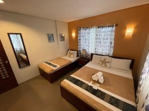 科隆Casa Coron Hotel的酒店客房设有两张床和窗户。