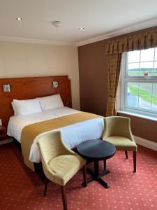 WressellLoftsome Bridge Hotel的酒店客房设有一张床、两把椅子和一扇窗户。