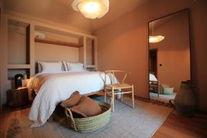 蓬德利马Vinha by NHôme的一间卧室配有一张床、一把椅子和镜子