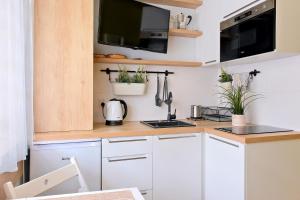 格但斯克Pokój 24E的厨房配有白色橱柜和植物台面