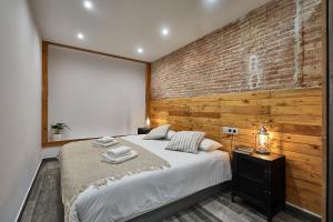 巴塞罗那BBarcelona Dúplex Poble Sec的一间卧室设有一张带砖墙的大床