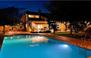 瓦伦西亚Agradable Villa junto al mar con piscina的夜间在房子前面的游泳池