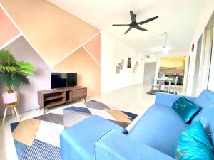 万挠De'Colour Stay at Country Homes Rawang的客厅配有蓝色的沙发和电视