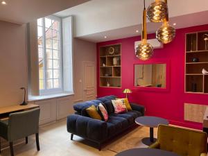 欧坦Suite avec Spa Quartier Cathédrale的客厅设有蓝色的沙发和红色的墙壁