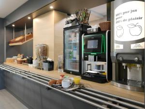 圣萨蒂南B&B HOTEL Le Mans Nord 2的一间带咖啡机的柜台的咖啡店
