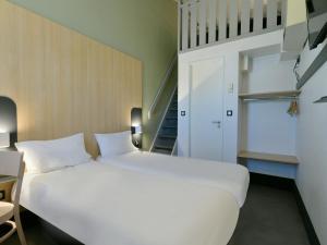 圣萨蒂南B&B HOTEL Le Mans Nord 2的楼梯间内的一张大白色床